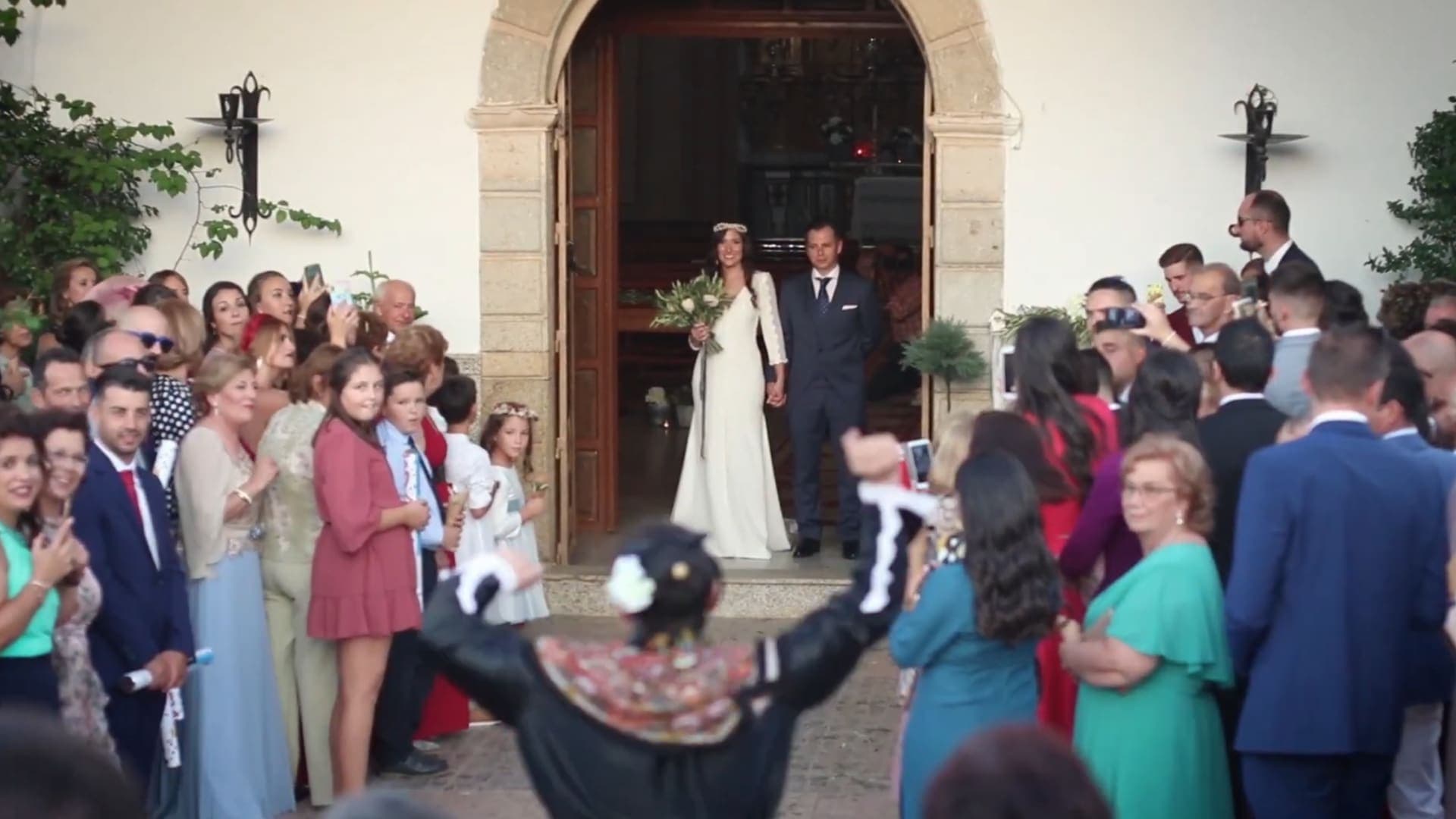Bride and groom leaving the church surrounded by guests